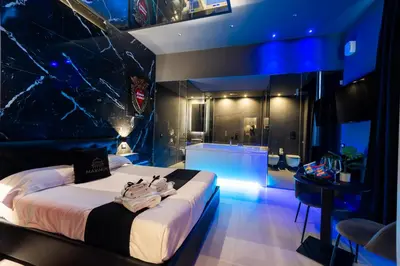 a bedroom with a large bed and a bathroom at Maximum Suite & Spa in Palermo