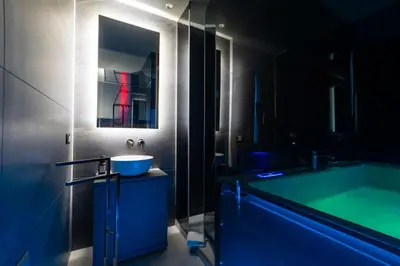 a bathroom with a blue sink and a tub at Maximum Suite & Spa in Palermo