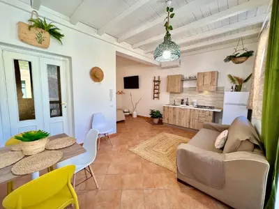 a living room with a couch and a table and a kitchen at da Mumminedda in Cinisi