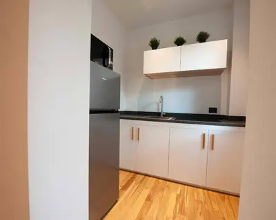 a kitchen with white cabinets and a stainless steel refrigerator at Palazzo al Carmine in Monreale
