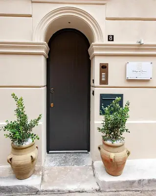 two large pots sitting in front of a door at Palazzo al Carmine in Monreale