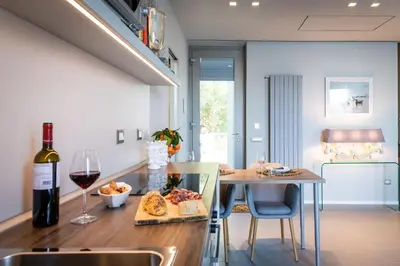 a table with a bottle of wine and a plate of food at NESOS SUITE by DomuSicily in Mondello