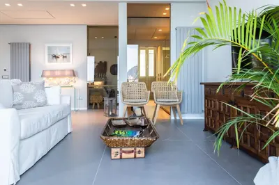 a living room with a white couch and chairs at NESOS SUITE by DomuSicily in Mondello
