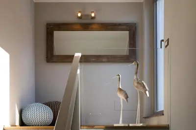 a mirror with two birds on display in a room at NESOS SUITE by DomuSicily in Mondello
