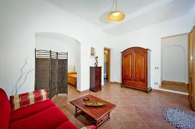 a living room with a red couch and a table at Apartment, Castellammare del Golfo in Castellammare del Golfo