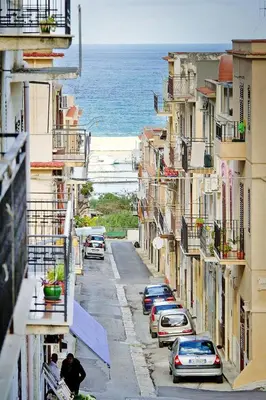 a city street with cars parked on the side of the ocean at Apartment, Castellammare del Golfo in Castellammare del Golfo
