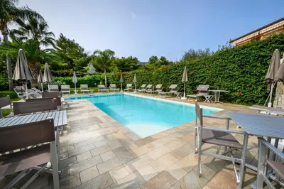 a swimming pool with chairs and umbrellas in a resort at Villa San Lorenzo in Palermo