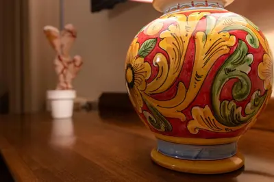 a colorful vase sitting on top of a wooden table at Villa San Lorenzo in Palermo