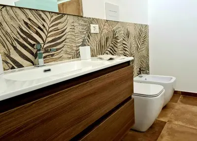 a bathroom with a sink and a toilet at SCRUSCIU HOME in Terrasini