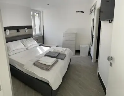 a bedroom with a large bed with towels on it at LA CASA DELLE FATE-Area Marina Protetta in Isola delle Femmine