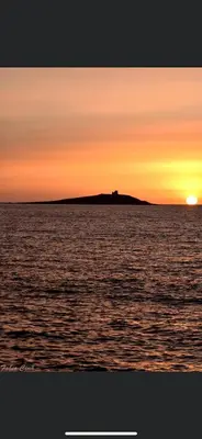 an island in the ocean with a sunset at LA CASA DELLE FATE-Area Marina Protetta in Isola delle Femmine