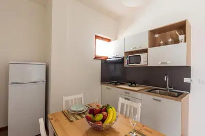 a kitchen with a table with a bowl of fruit on it at Mondello Sabrina Apartments in Mondello