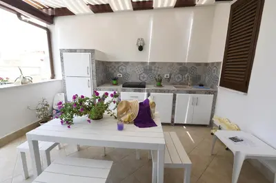 a kitchen with a white table with flowers on it at Terra Sinus Beautiful Suite in Terrasini