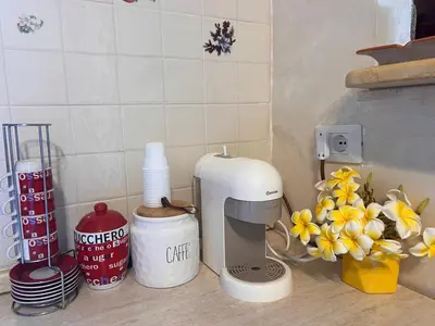 a kitchen counter with a coffee maker and flowers at Villa indipendente in Altavilla Milicia