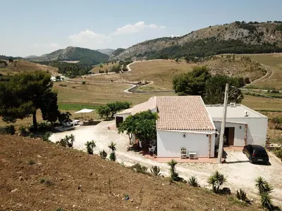 a small white house in the middle of a field at Helimos B&B with Segesta Temple view near Castellammare del Golfo in Calatafimi