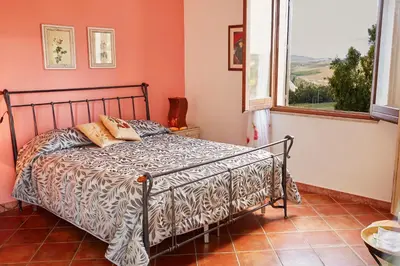 a bedroom with a bed in a room with a window at Helimos B&B with Segesta Temple view near Castellammare del Golfo in Calatafimi