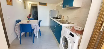 a small kitchen with a table and a washing machine at Romantic apartment with sea view in Alcamo - Terrace & BBQ in Alcamo