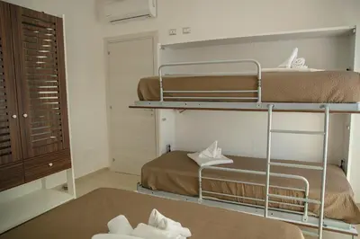 a room with two bunk beds in a room at SanvitoTour - Scala del Mare in San Vito lo Capo