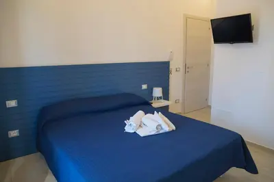 a bedroom with a blue bed with towels on it at SanvitoTour - Scala del Mare in San Vito lo Capo