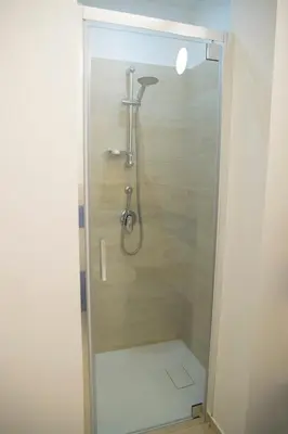 a shower with a glass door in a bathroom at SanvitoTour - Scala del Mare in San Vito lo Capo