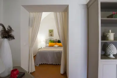 a bedroom with a bed with orange and green pillows at Capo Rama Suites & Rooms in Terrasini