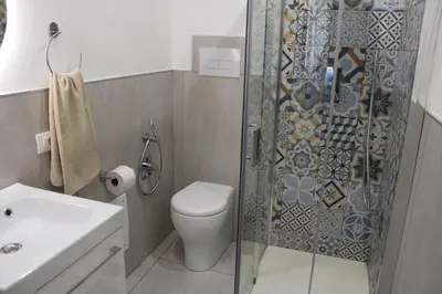 a bathroom with a shower and a toilet and a sink at Casetta Delia in Palermo