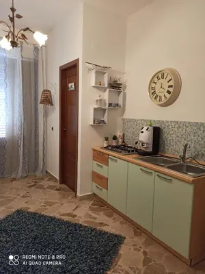 a kitchen with a sink and a clock on the wall at Sicilia bedda 1 in Isola delle Femmine