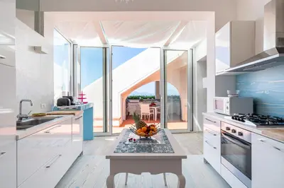 a kitchen with a table with a bowl of fruit on it at Splendida Villa con vista mozzafiato e piscina in Terrasini