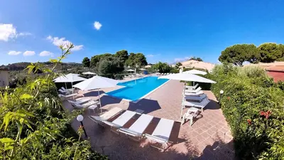 an outdoor swimming pool with lounge chairs and umbrellas at Villa Teti - Sicilia in Campofelice di Roccella