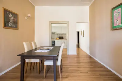a dining room with a table and white chairs at Cathedral View Apartments in Palermo