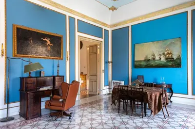 a room with blue walls and a table and a chair at Cathedral View Apartments in Palermo