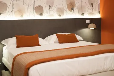 a bedroom with a bed with white sheets and orange pillows at Bri&Bri Mondello in Palermo