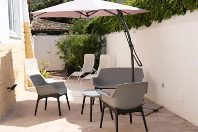 a group of chairs and a table with an umbrella at Bri&Bri Mondello in Palermo