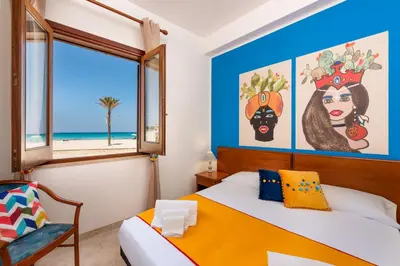 a bedroom with a bed and a window at I Tre Golfi Beach Apartments in San Vito lo Capo