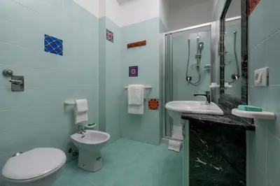 a bathroom with a toilet and a sink and a shower at I Tre Golfi Beach Apartments in San Vito lo Capo