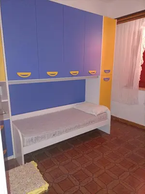 a small room with blue cabinets and a small bed at LA FINESTRA SUL MARE PIANO Terra in Trappeto