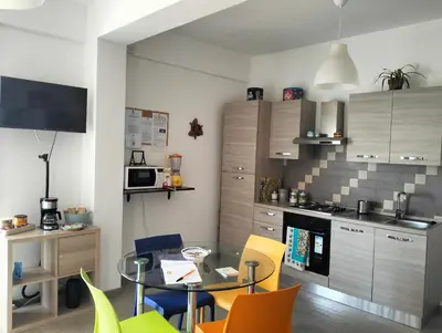 a kitchen with a table and chairs in a room at La Casa di Andly in Palermo