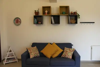a blue couch in a living room with shelves on the wall at La Casa di Andly in Palermo
