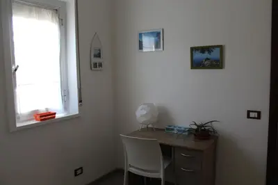 a desk with two chairs and a window in a room at La Casa di Andly in Palermo