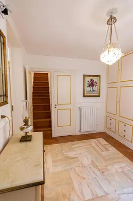 a living room with a table and a chandelier at Le Rose di Nonna Maria, appartamento di lusso in centro città in Palermo