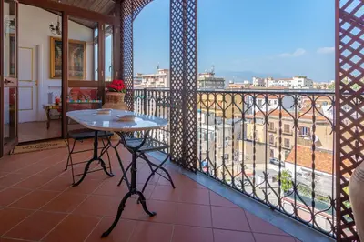 a balcony with a table and a view of a city at Le Rose di Nonna Maria, appartamento di lusso in centro città in Palermo
