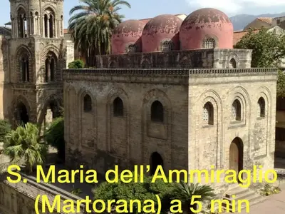 a building with a clock tower and a church at La Siciliana-di fronte la Cattedrale in Palermo