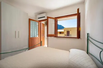 a bedroom with a bed and a window at Appartamento Blusanvito 1° Piano in San Vito lo Capo