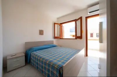 a small bedroom with a bed and a window at Appartamento Blusanvito 1° Piano in San Vito lo Capo