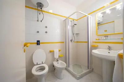 a bathroom with a toilet and a shower and a sink at Appartamento Blusanvito 1° Piano in San Vito lo Capo