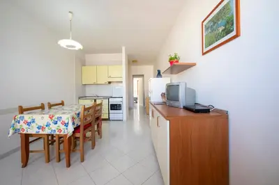 a kitchen and dining room with a table and a television at Appartamento Blusanvito 1° Piano in San Vito lo Capo
