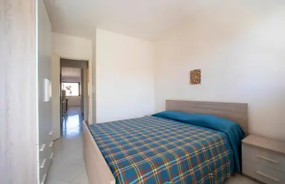 a bedroom with a bed with a blue blanket at Appartamento Blusanvito 1° Piano in San Vito lo Capo