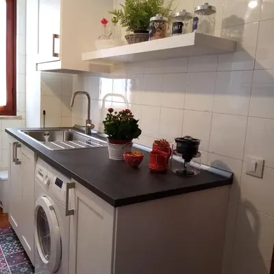 a kitchen with a sink and a washing machine at Casa Rosamarina in Mondello