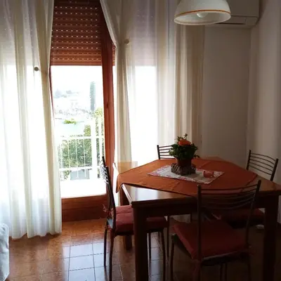 a dining room with a table and chairs and a window at Casa Rosamarina in Mondello