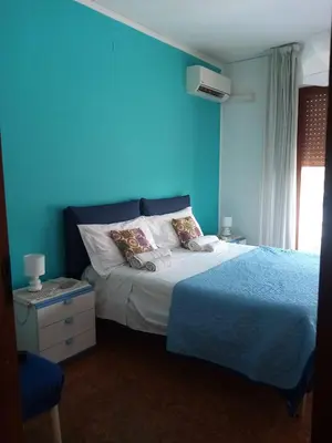 a bedroom with blue walls and a bed with pillows at Casa Rosamarina in Mondello